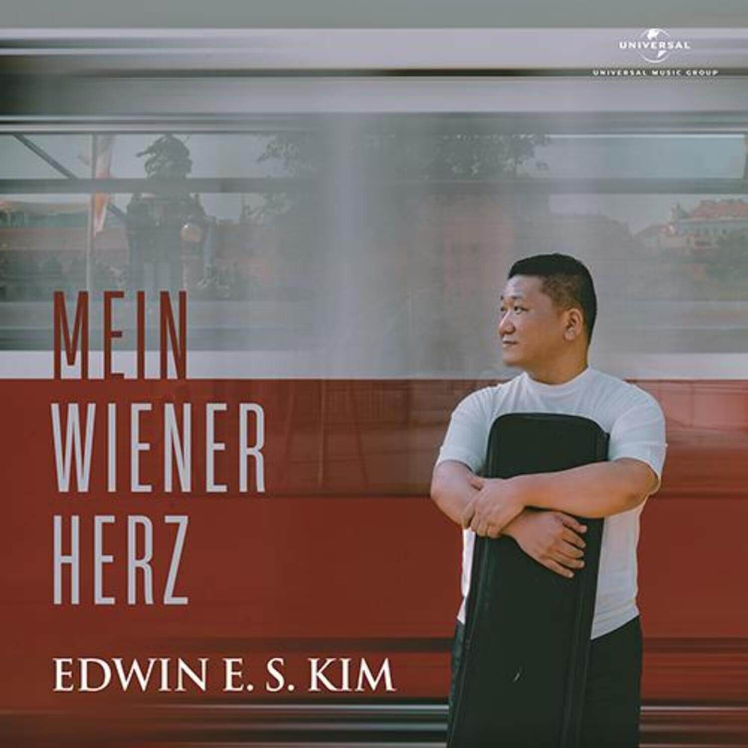 EDWIN E.S. KIM - [MEIN WIENER HERZ] - Album Kpop : photo du chanteur devant affiche “MEIN WIENER HERZ” en ville.