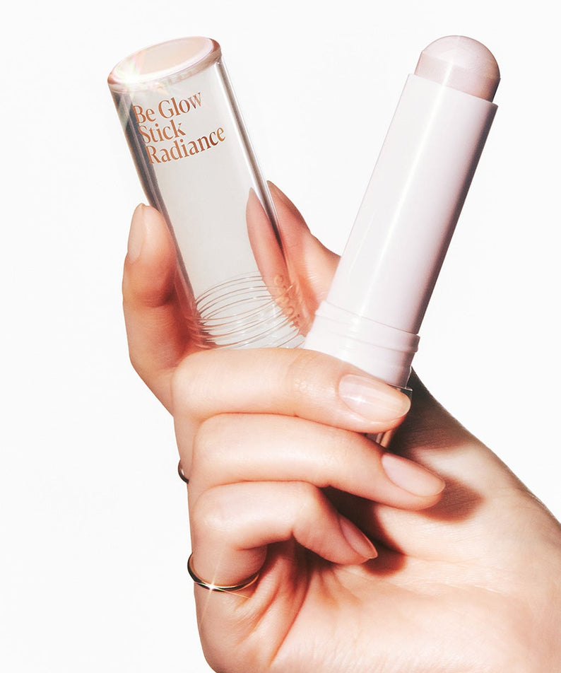 Main en train d'appliquer le produit de beauté ESPOIR BE GLOW STICK RADIANCE pour un éclat lumineux. Parfait pour améliorer l'éclat naturel.