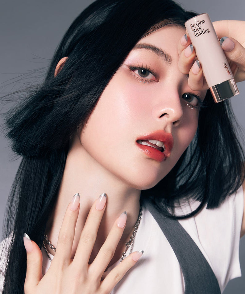 Femme posant avec ESPOIR BE GLOW STICK SHADING, maquillage éclatant, lumière douce, accent sur la peau lumineuse, cosmétique beauté.