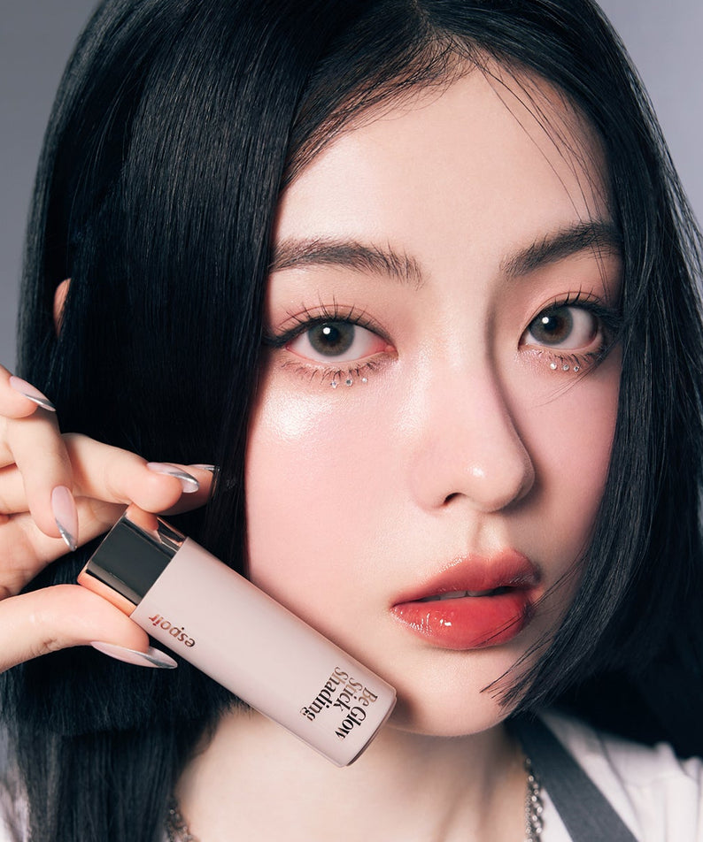 Femme tenant ESPOIR BE GLOW STICK SHADING, maquillage lumineux et peau éclatante, produit cosmétique élégant et moderne