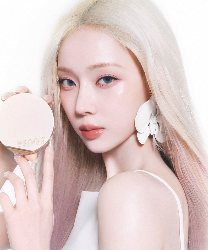 Femme tenant ESPOIR BE GLOW VOLUME CUSHION SPF42 PA+++ avec un look élégant et moderne, maquillage naturel