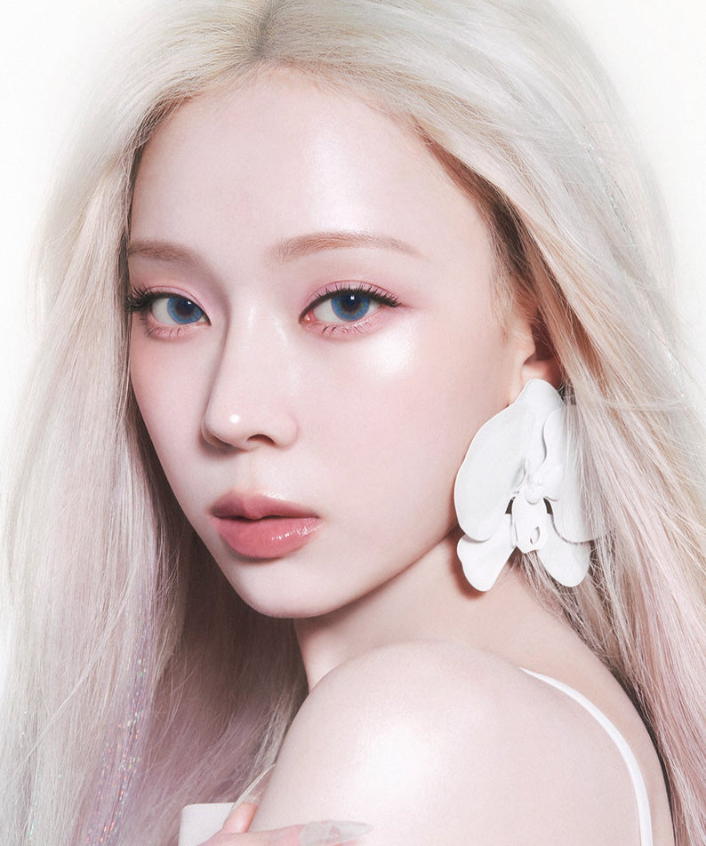 Femme au look élégant portant un accessoire floral blanc, mettant en valeur la beauté moderne et sophistiquée.