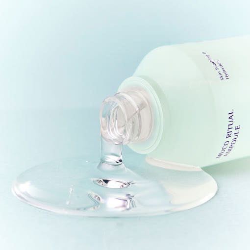 ESSENHERB Mucoritual Ampoule 120ml : flacon crème blanc avec produit coulant, contexte visuel esthétique en studio.