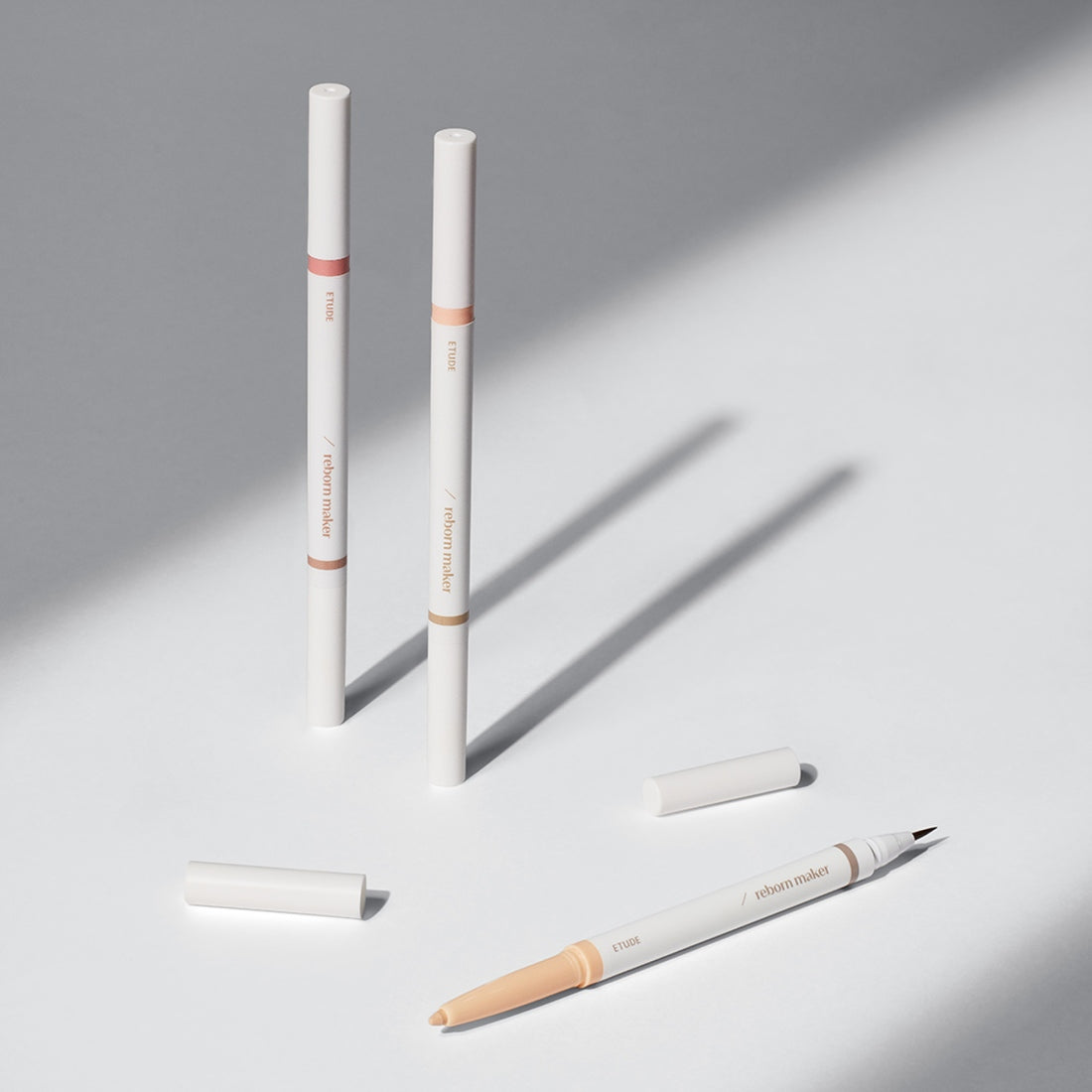ETUDE Re-creation Maker Aegyo-Sal Liner, stylos pour les lèvres de la marque ETUDE, sur fond gris clair.