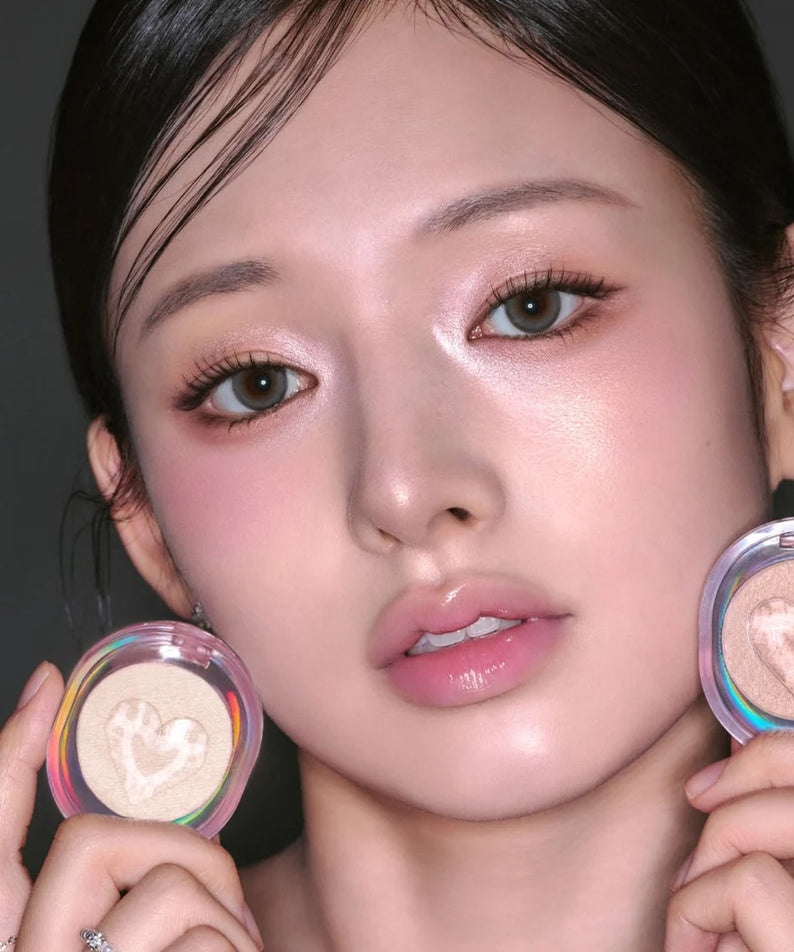 Femme appliquant ETUDE Shooting Beam Highlighter 3g avec reflets lumineux sur son visage pour un look éclatant.