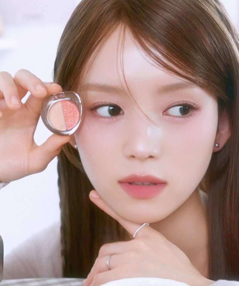 Jeune femme tenant ETUDE What's in My Eyes Cafe Double, maquillage des yeux tendance.