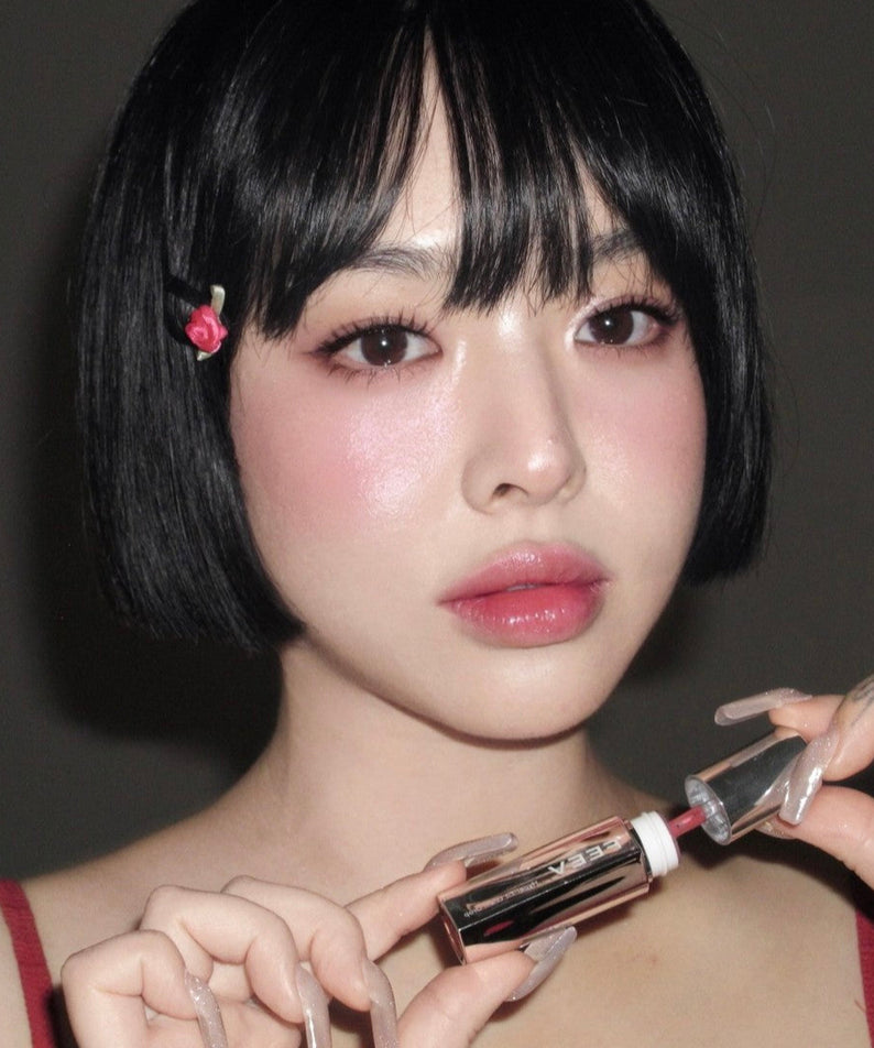 Femme appliquant FEEV Hyper-Fit Glam Drop pour un look radieux et glamour