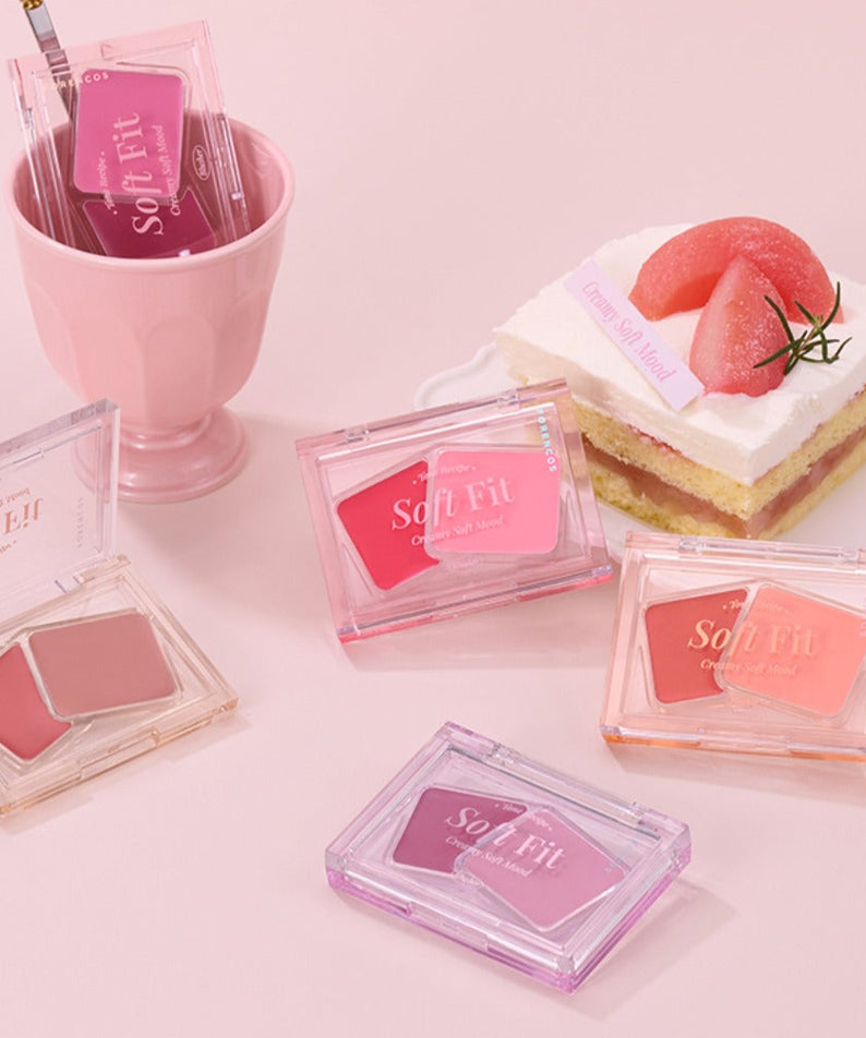 Présentation du FORENCOS Soft Fitting Cream Blusher sur une table rose avec des desserts.