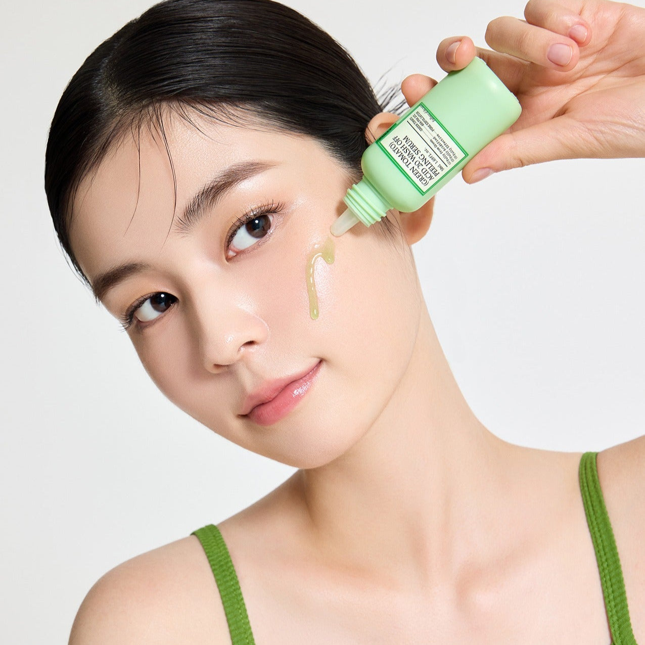 Décris l'image en français : FULLY  Green Tomato Acid 20 Wash-Off Peeling Serum 50ml, la marque, application sur le visage.