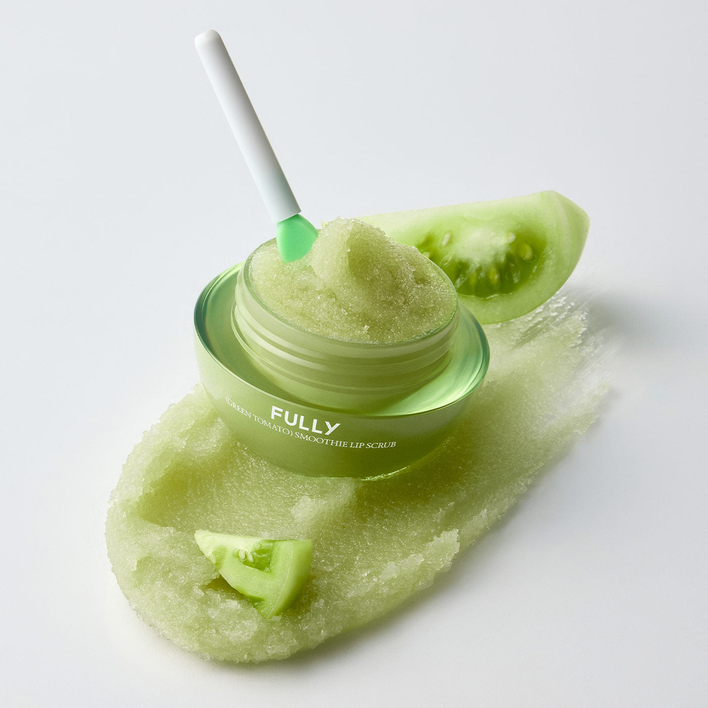 FULLY Green Tomato Smoothie Lip Scrub 12g : pot de scrub vert et texture sur spatule, marque FULLY, fond clair.