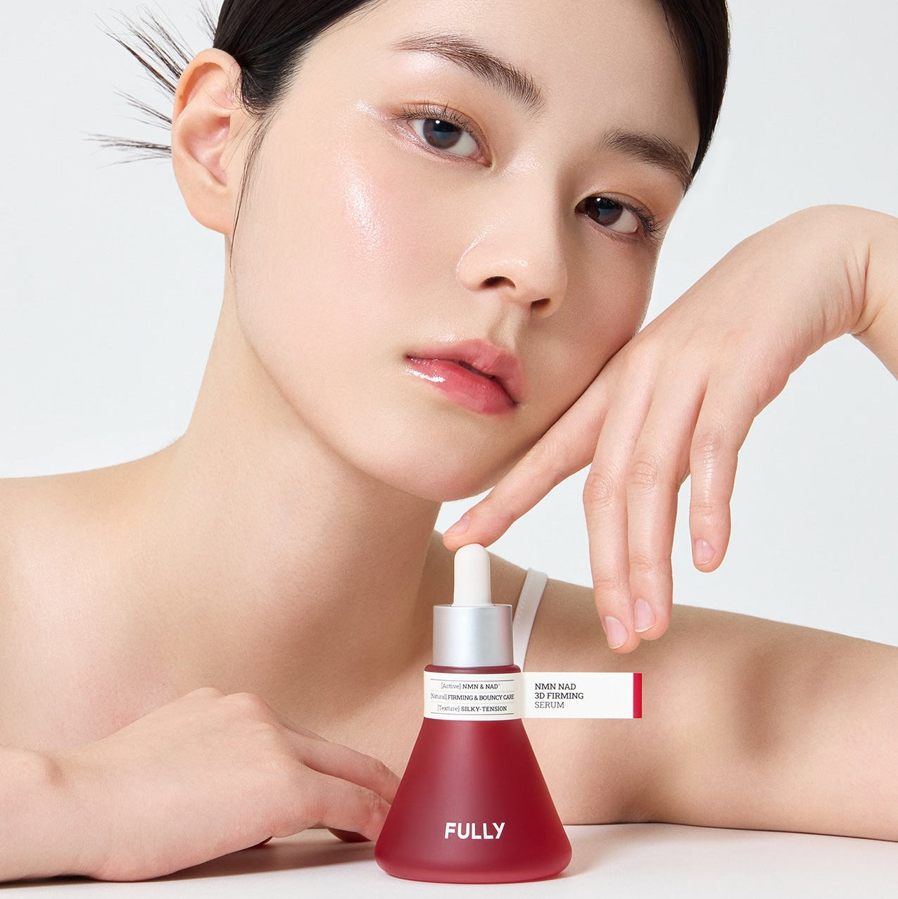 FULLY  NMN NAD Elasticity Serum, marque FULLY, sérum pour l’élasticité, sur peau éclatante, visage et flacon en studio