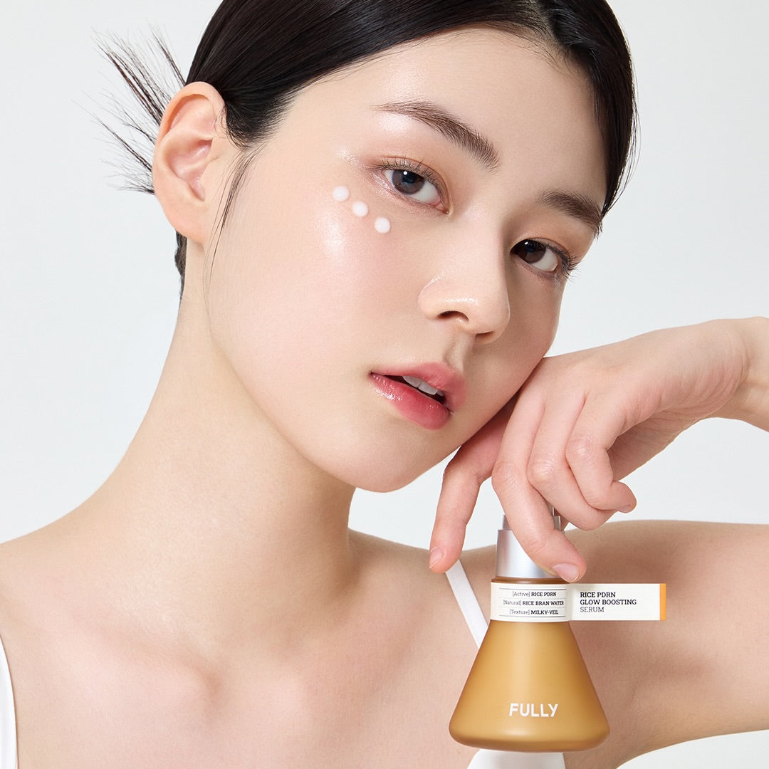 FULLY  Rice PDRN Radiance Serum : femme asiatique applique la crème, pot FULLY, peau lumineuse sur fond clair.