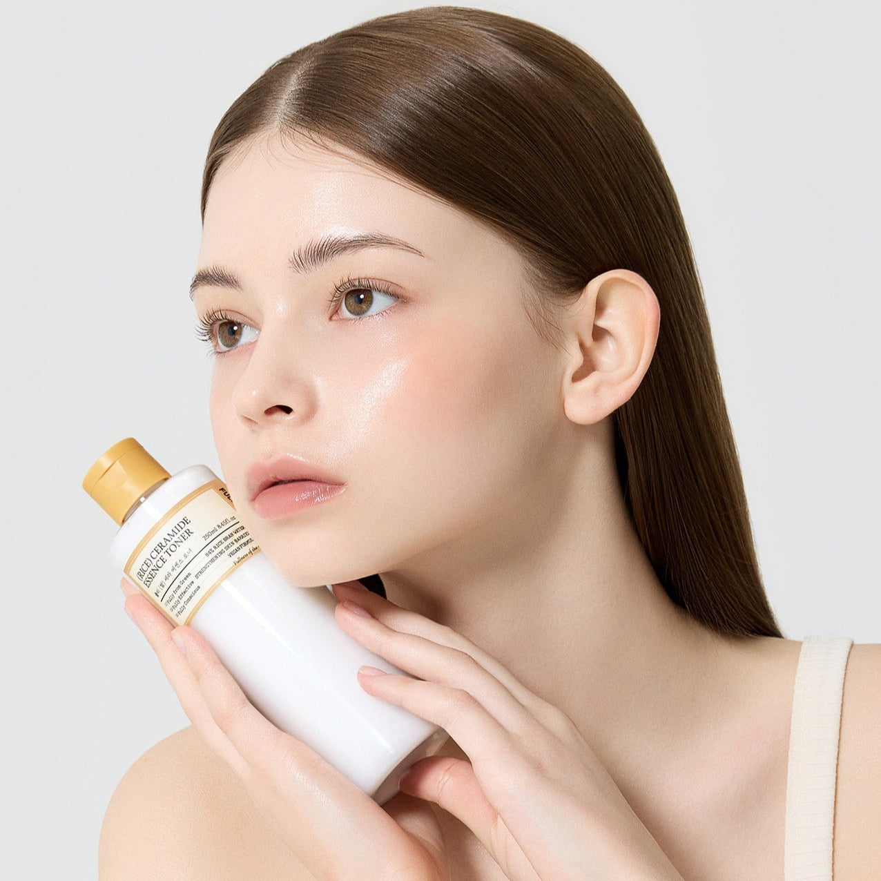 FULLY  Rice Serum Essence Toner 250ml de la marque FULLY, femme appliquant le produit en salle de bain.