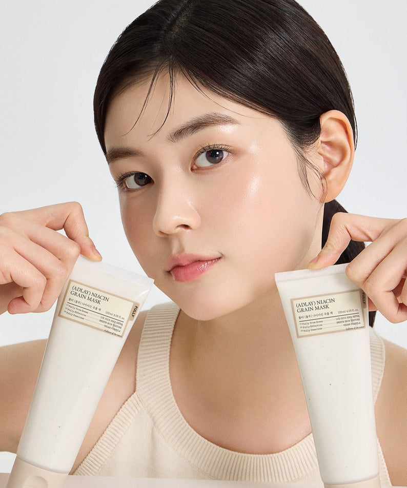 Jeune femme tenant des tubes de soin de peau, conservant un aspect lumineux et éclatant.