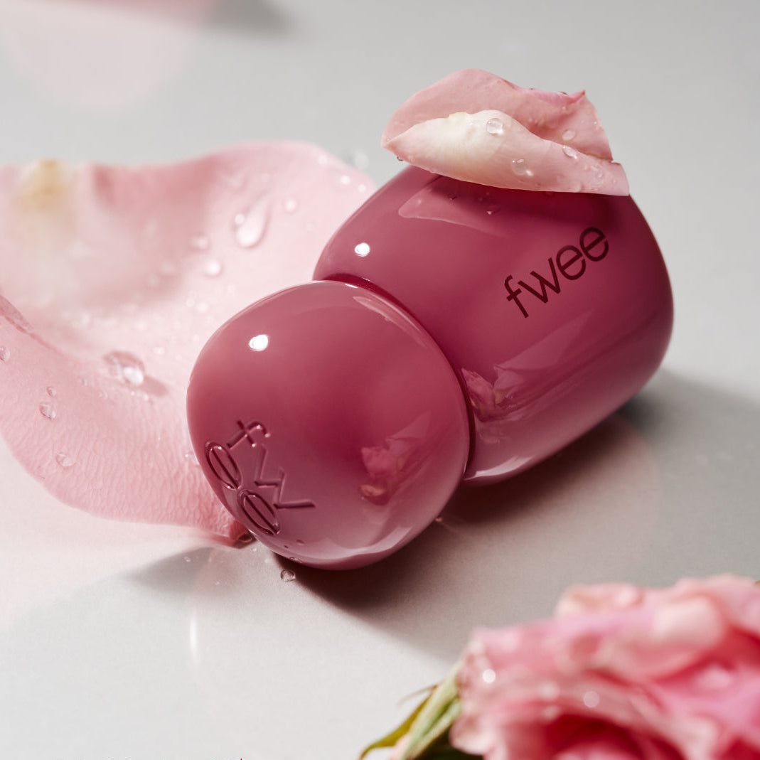 FWEE Rose Obsession 18 colors, tube maquillage rose fwee sur fond fleurs, gouttelettes, image produit.