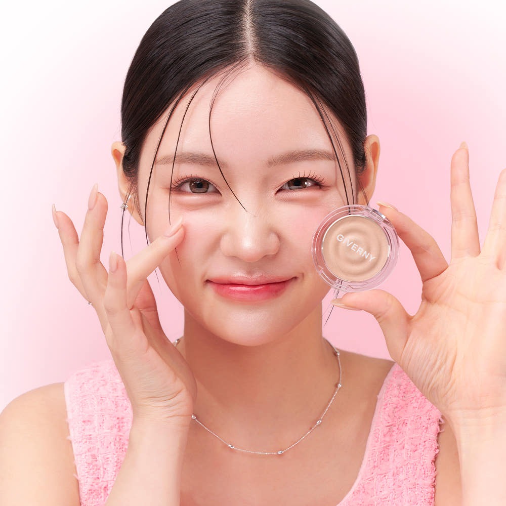 GIVERNY Dewy Voluming Highlighter 3g, marque GIVERNY : femme appliquant le highlighter, boîtier sur fond rose pastel.
