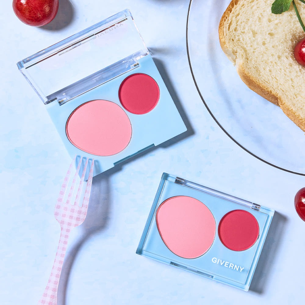 GIVERNY Fluffy Dual Blusher 7.4g de la marque GIVERNY, compact double blush sur fond bleu avec maquillage.