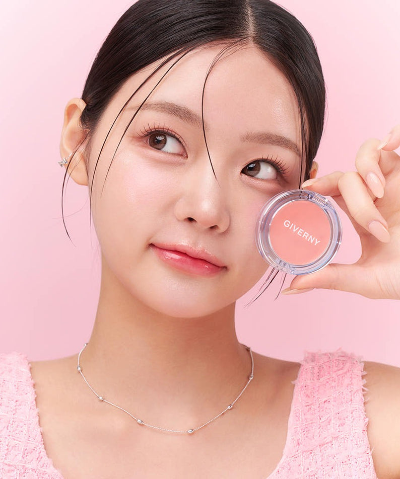Jeune femme souriante tenant GIVERNY Dewy Gel Glow Blusher 2.7g, maquillage moderne sur fond rose.