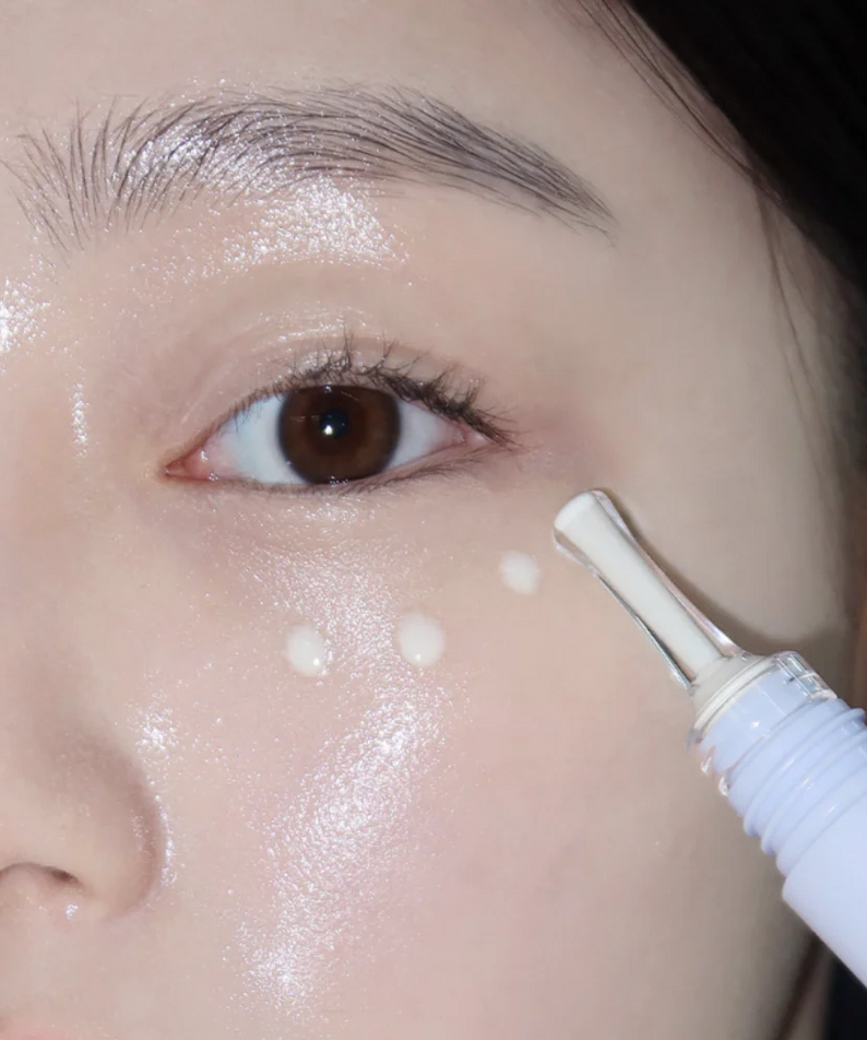 GLOW Apple Retinol Eye Cream 15ml de GLOW, gros plan sur application autour de l’œil, sérum crémeux et visage maquillé