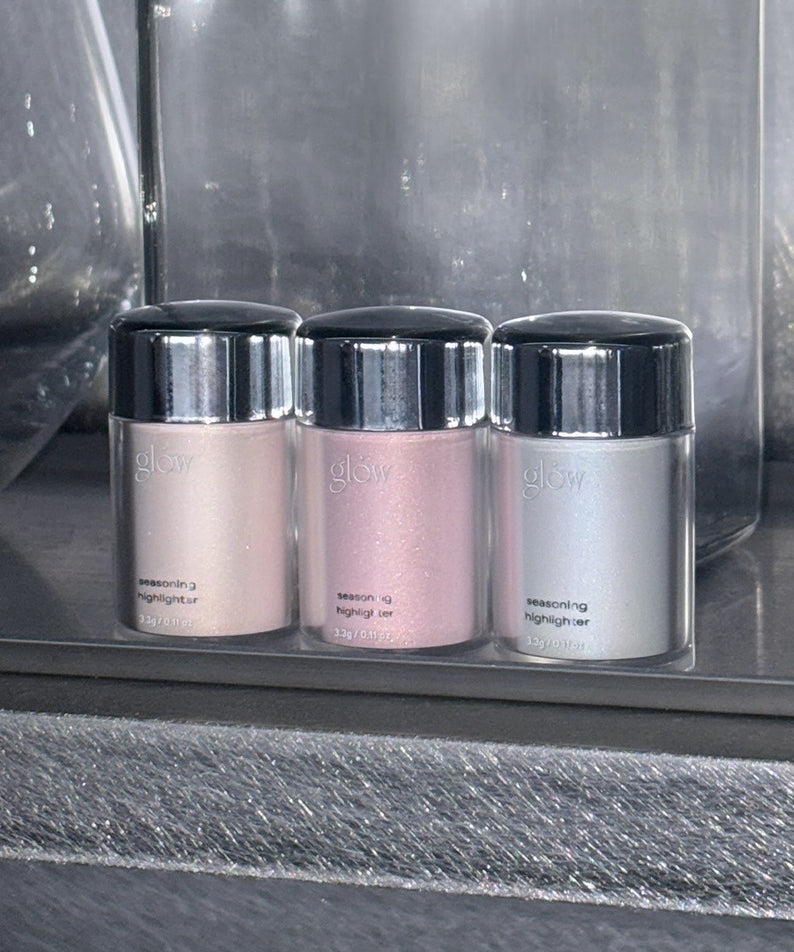 GLOW Seasoning Highlighter de la marque Glow, pots colorés rose et argent sur plateau vitré en boutique