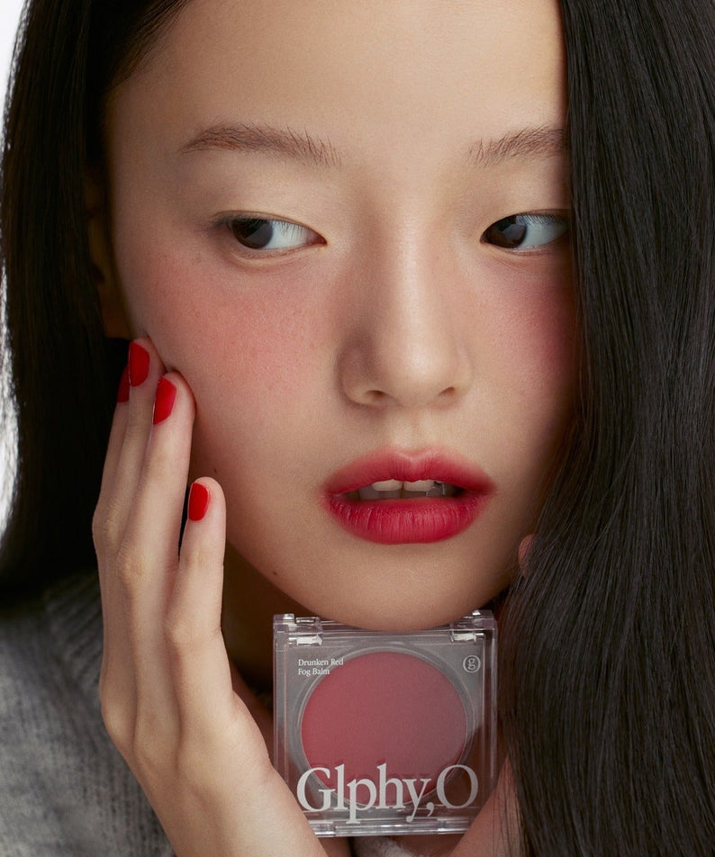 GLPHYO Fog Balm3.2g de la marque GlphyO, maquillage lèvres et main sur visage, contexte beauté en gros plan.