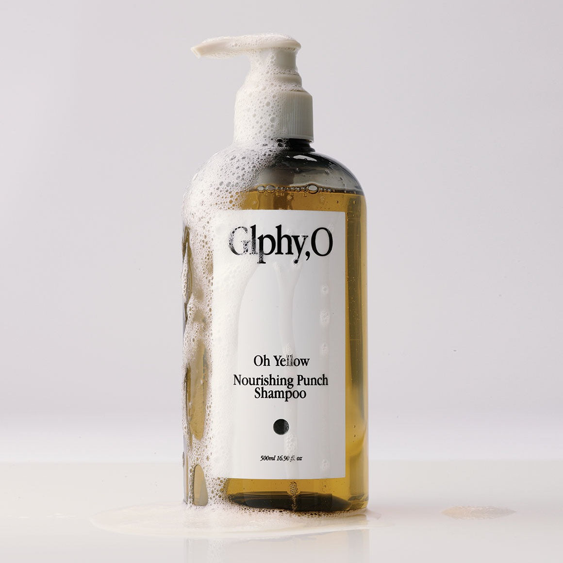 GLPHYO Oh Yellow Nourishing Punch Shampoo 500ml de la marque Glphy,O, bouteille jaune sur fond blanc, mousse visible.