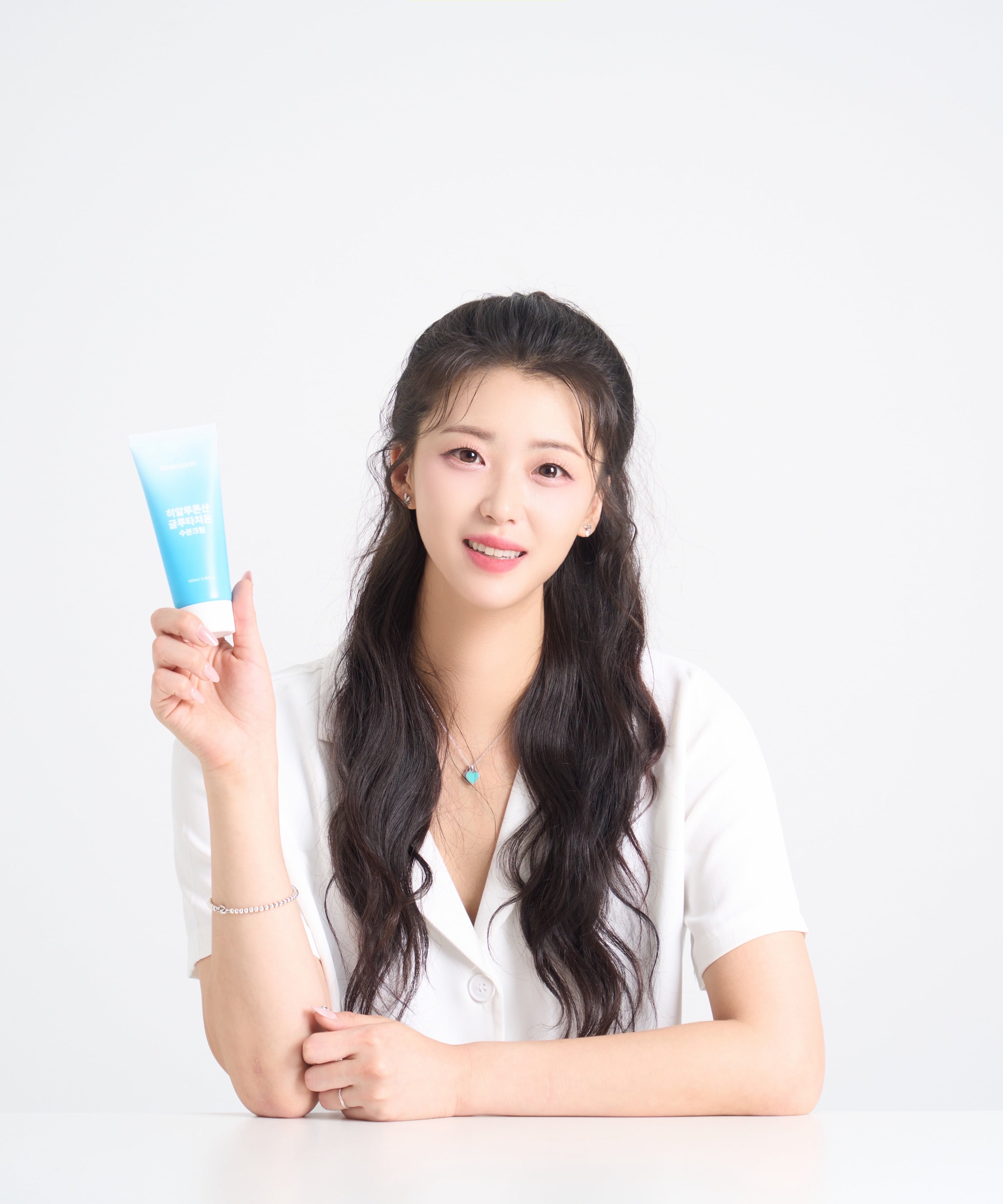 GONGSKIN Hyaluronic Acid Glutathione Moisturizing Cream 100ml, femme en studio tenant le tube bleu sur fond clair.