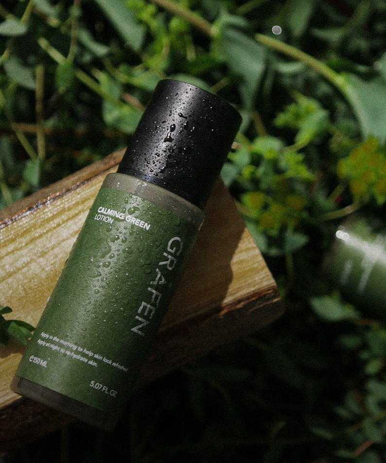 GRAFEN  Calming Green Lotion 150ml, lotion verte apaisante sur support bois, gouttes d’eau et fond végétal vert.