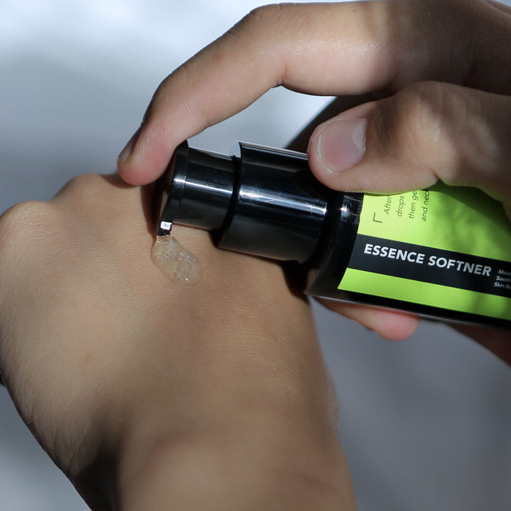 GRAFEN  Calming Green Serum 50ml, main appliquant le sérum vert apaisant, flacon vert sur peau, contexte soin visage.