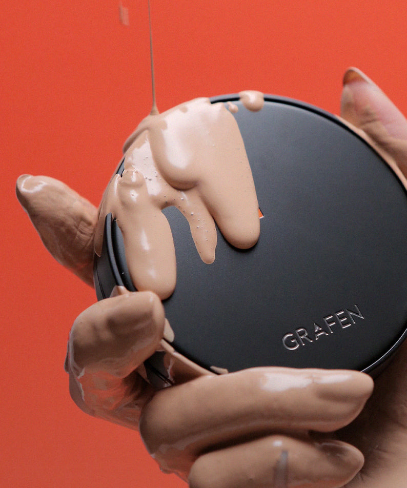 GRAFEN Handsome Cover Cushion 14g : mains tenant le produit sur fond rouge, crème crème pour la peau.
