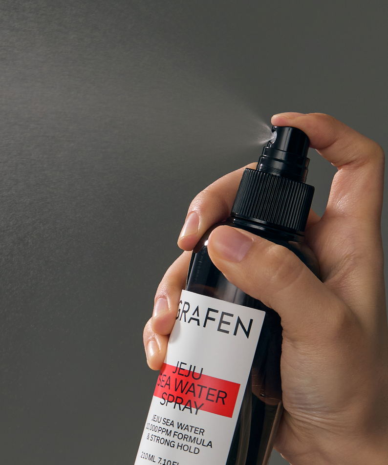 GRAFEN  Jeju Sea Water Spray 210ml : main tenant le spray sur fond gris, marque GRAFEN en gros plan.
