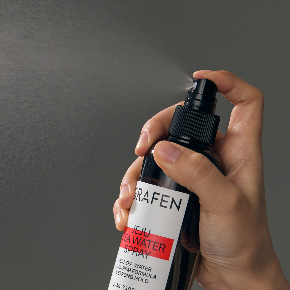 GRAFEN  Jeju Sea Water Spray 210ml : main tenant le spray sur fond gris, marque GRAFEN en gros plan.