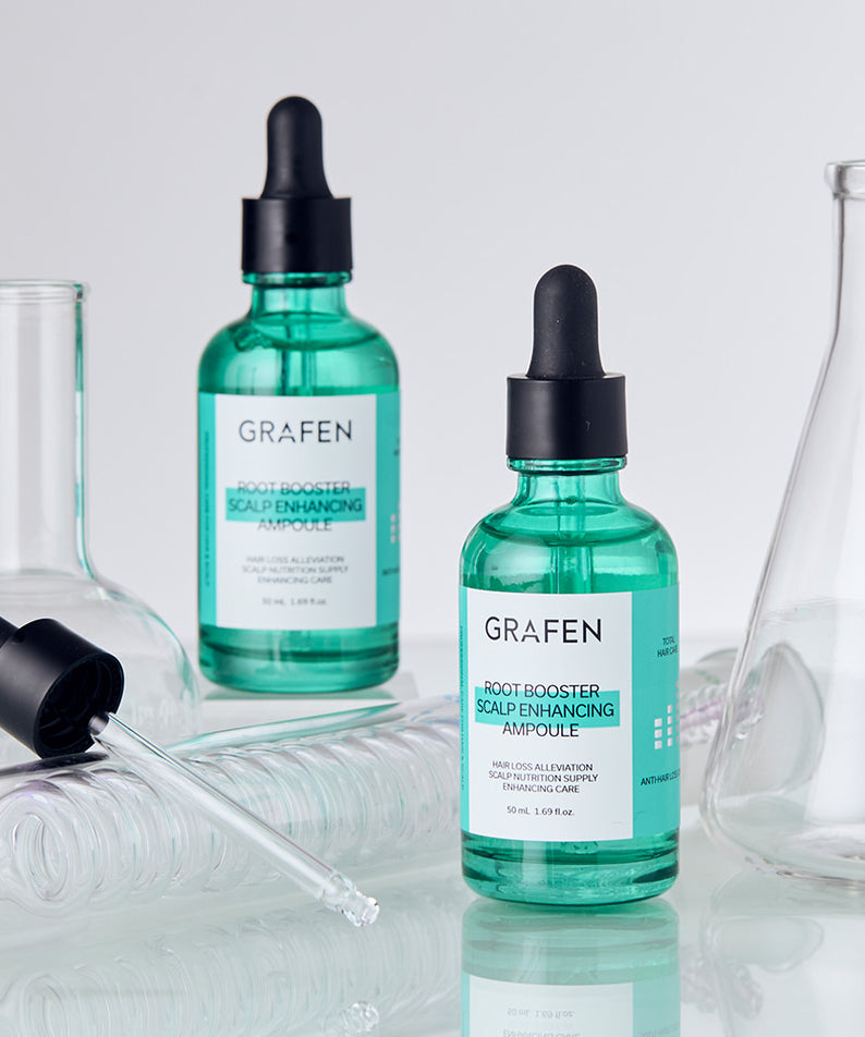 Décris l'image en français : flacons GRAFEN Root Booster Ampoule 50ml, ambiance salle de bain sur fond clair.