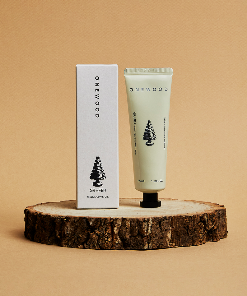 Décris l'image en français: GRAFEN Tattoo Perfume™ One Wood Hand Cream 50ml sur un support en bois, marque GRAFEN.