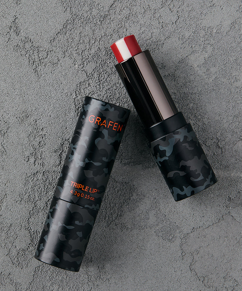 GRAFEN Triple Lip™ 4.3g sur fond béton gris, tube et stick camo rouge/noir, produit cosmétique de la marque GRAFEN.