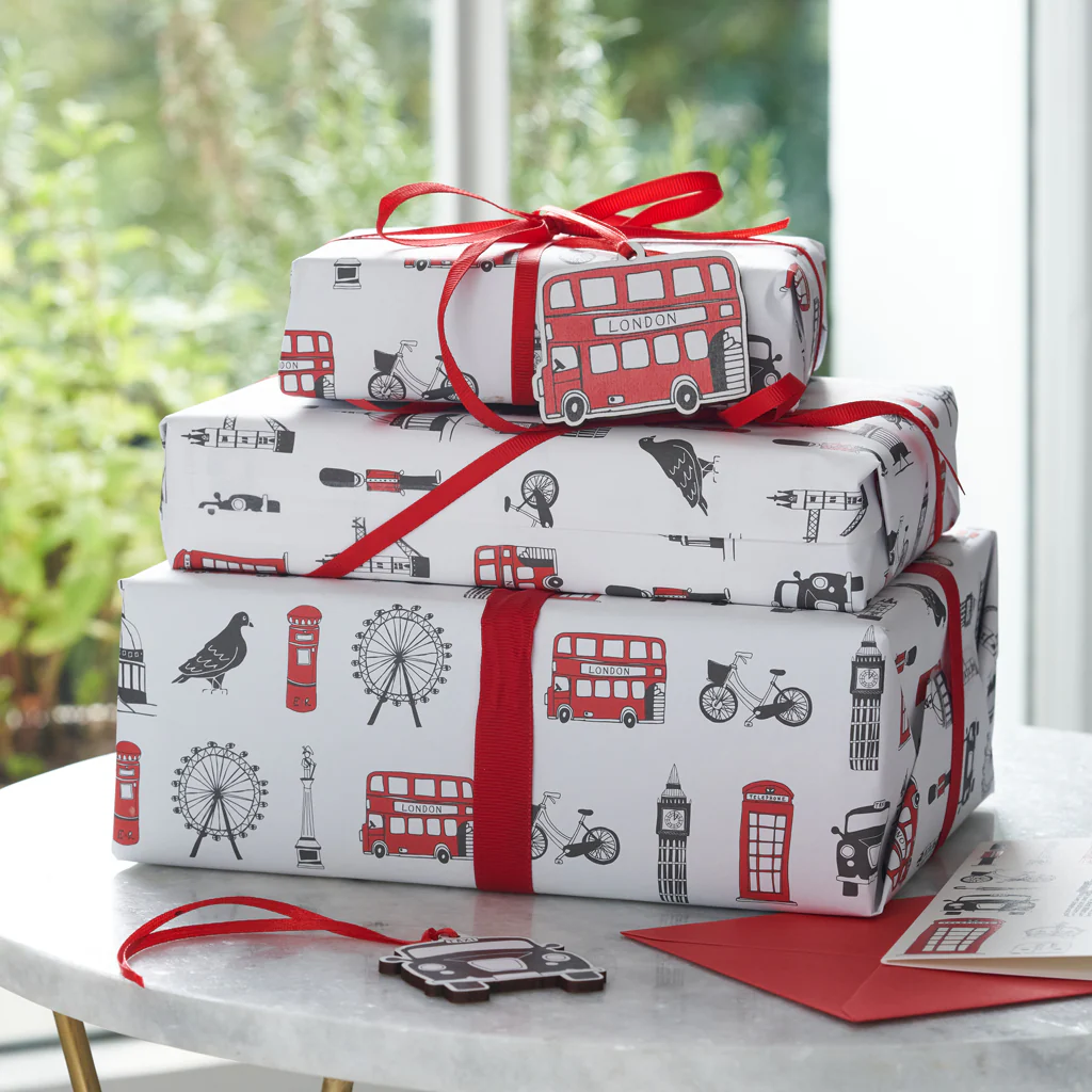 Gift Wrapping : emballage cadeau avec ruban rouge et décor Londres, sur table près d’une fenêtre, protection à l’expédition.
