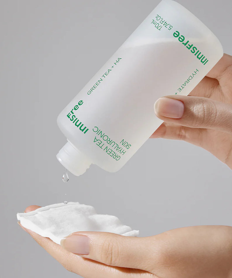 INNISFREE Green Tea Hyaluronic Skin 170ml, bouteille et crème, main appliquant le soin visage, arrière-plan gris.
