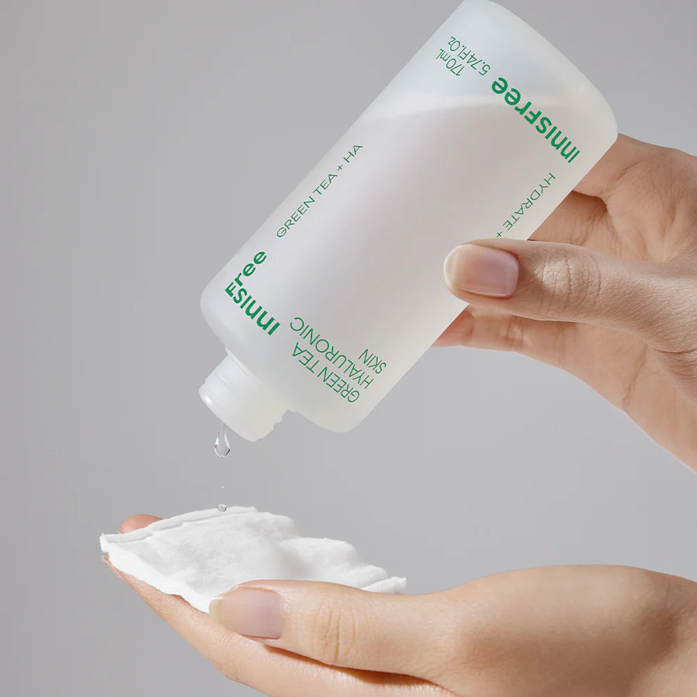 INNISFREE Green Tea Hyaluronic Skin 170ml, bouteille et crème, main appliquant le soin visage, arrière-plan gris.