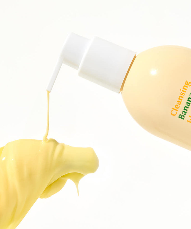 Main tenant HANSKIN Cleansing Banana Milk & Blackhead PHA 200ml, flacon de marque sur fond clair, texture crème
