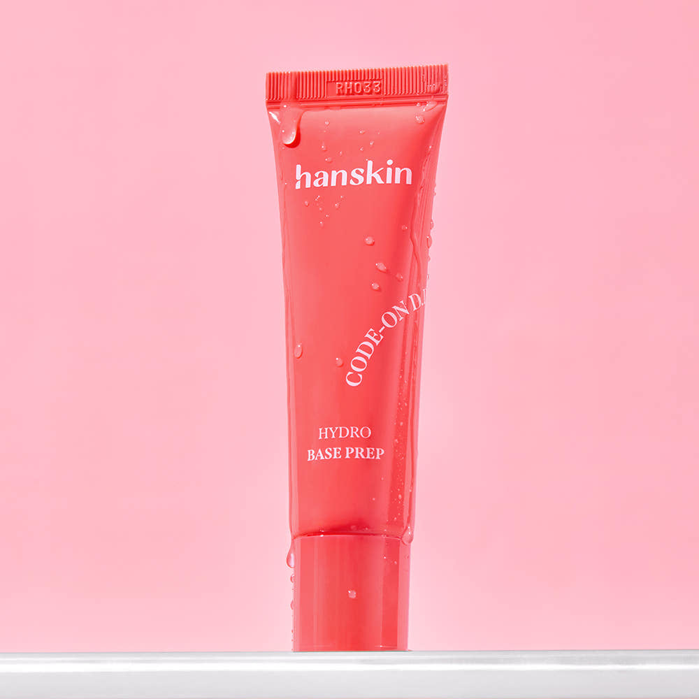 HANSKIN Code On DD Hydro Base Prep 30ml, tube rouge sur fond rose, gouttes et ambiance skincare.