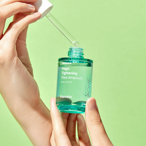 HANSKIN Magic Tightening Pore Ampoule 30ml, flacon vert tenu par des mains sur fond vert, serum tightening pores