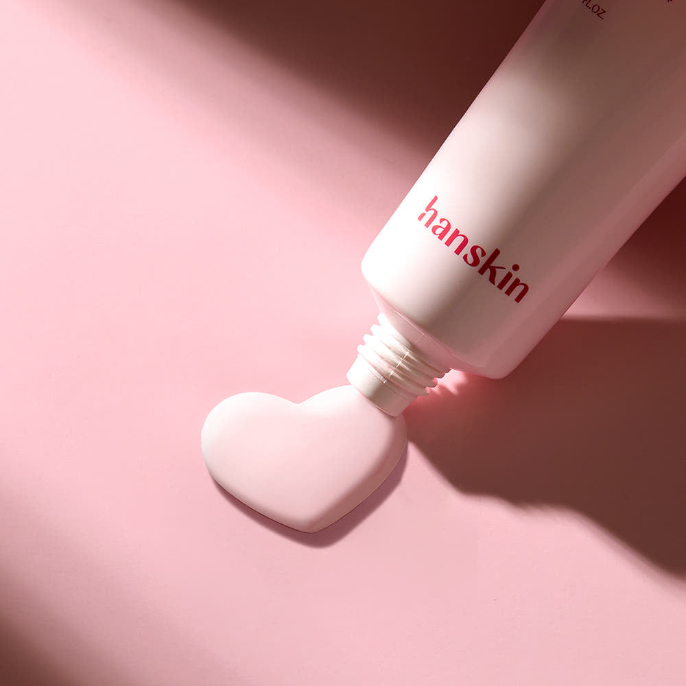 HANSKIN Pink Vita Blemish Toning Sun Cream 50ml, tube rose hanskin sur fond rose, crème solaire anti-blemishes en gros plan