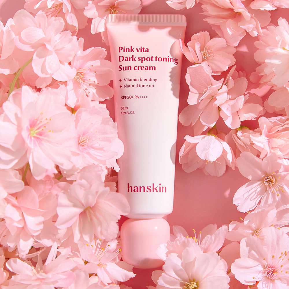 HANSKIN Pink Vita Blemish Toning Sun Cream 50ml, tube rose dans des fleurs, crème solaire tonifiante, visuel produit HANSKIN.