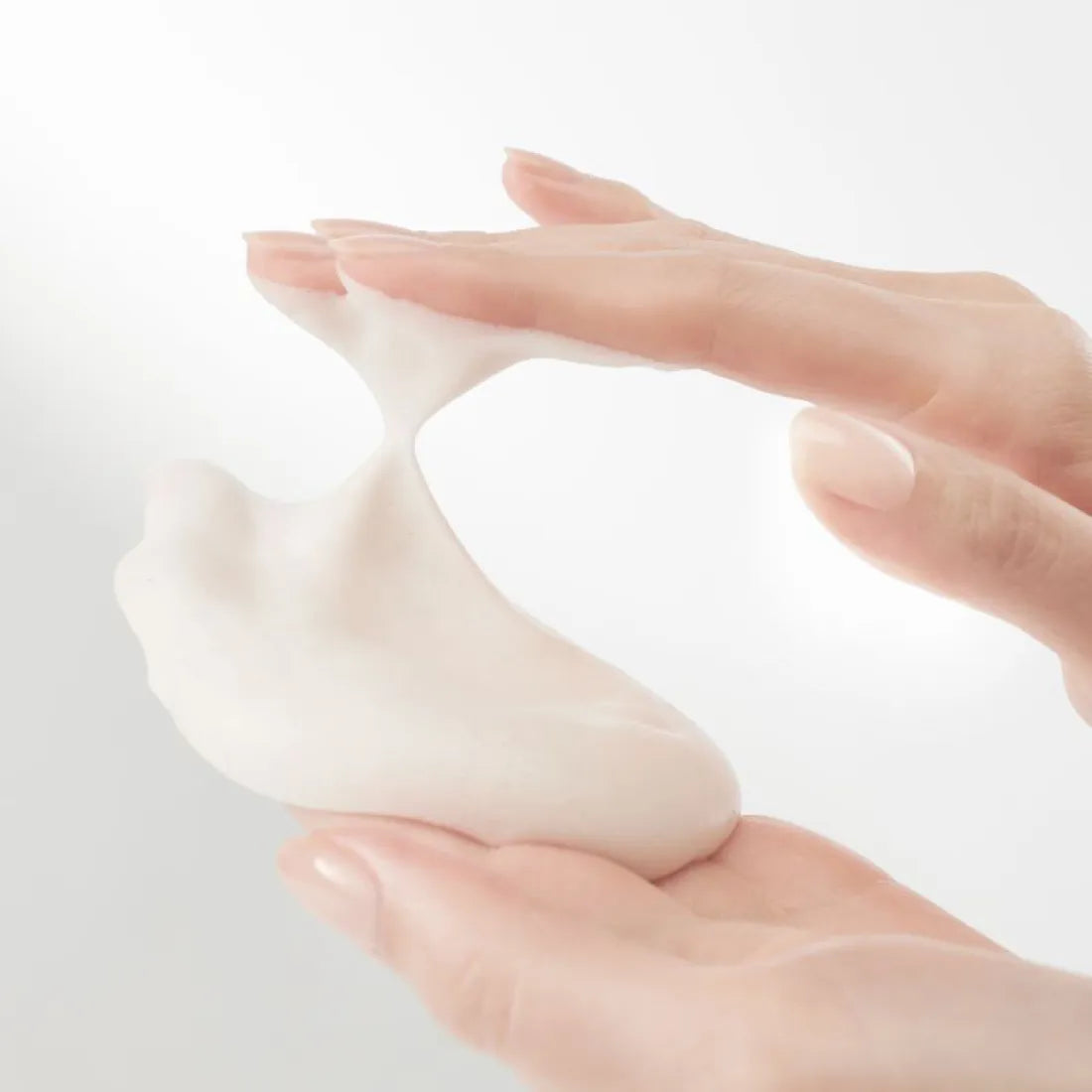HANYUL Extreme Cream Cleansing Foam 200ml, mousse de nettoyage crème HANYUL sur mains, contexte visuel blanc