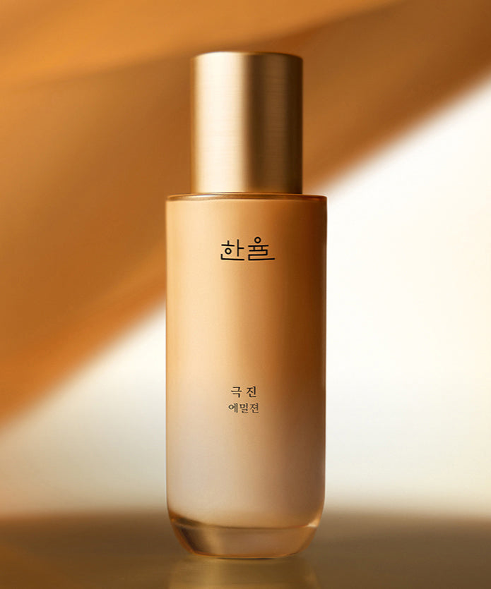 HANYUL Extreme Emulsion 125ml, flacon doré sur fond beige chaud, éclairage studio élégant.
