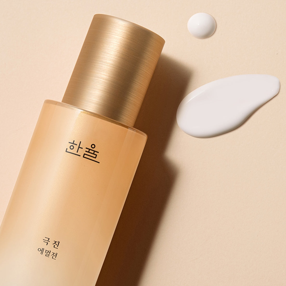 HANYUL Extreme Emulsion 125ml, bouteille et texture de crème sur fond beige avec ruban doré, marque visible.