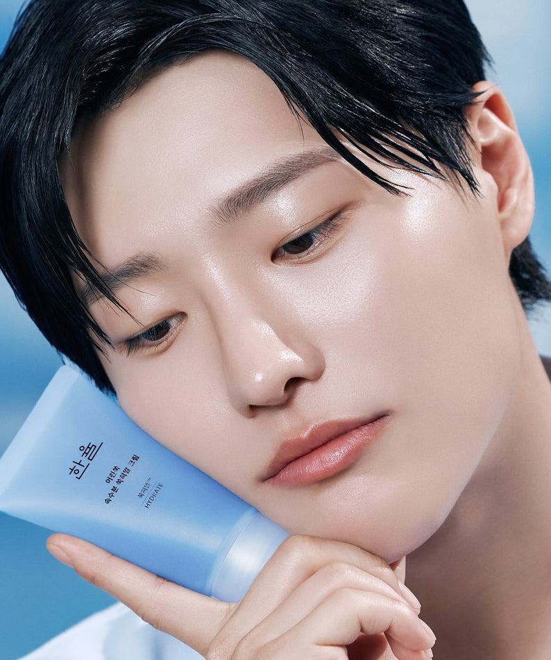 HANYUL Young Artemisia Extract Moisturizing Cream 60ml : crème hydratante HANYUL, modèle visage avec tube bleu sur fond ciel