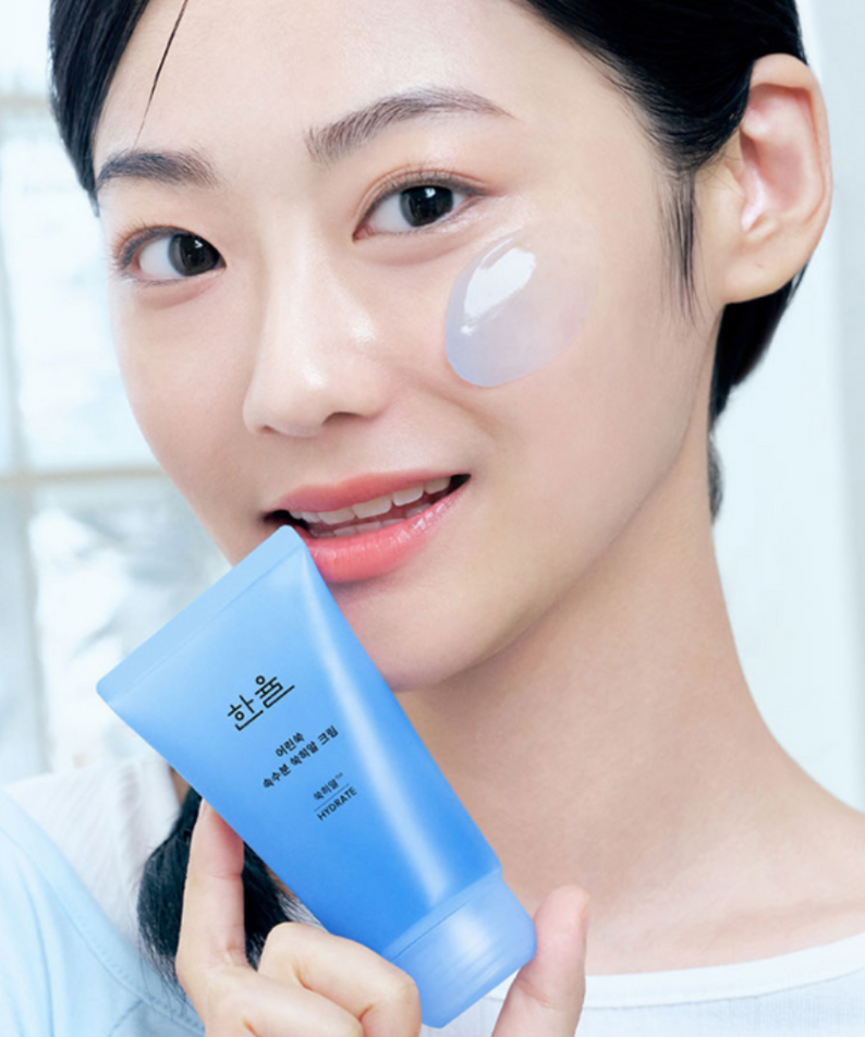 HANYUL Young Artemisia Extract Moisturizing Cream 60ml, tube bleu près du visage, soin hydratant sur peau de femme