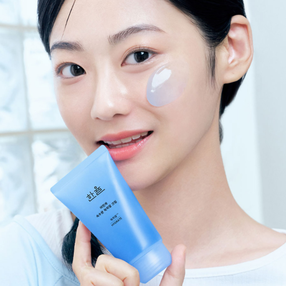 HANYUL Young Artemisia Extract Moisturizing Cream 60ml, tube bleu près du visage, soin hydratant sur peau de femme