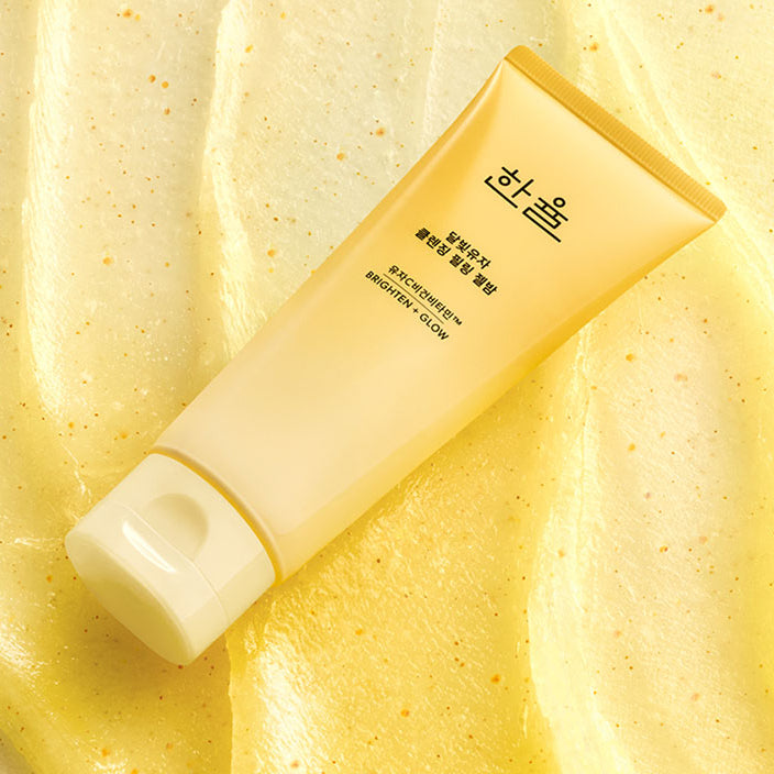 HANYUL Yuja Brightening Peeling Gel Balm Cleanser 100g, tube jaune sur fond crème, look lumineux et éclats d’agrume.